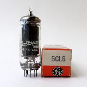 May include: A vintage General Electric 6CL6 vacuum tube in its original box. The tube is made of glass and metal and has a black label that reads "Electronic Tube Made in U.S.A.". The box is red and white and has the General Electric logo and the text "6CL6".