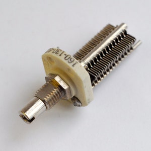 May include: A silver and white variable capacitor with the text "190-130" printed on the side.