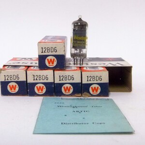 May include: A collection of vintage Westinghouse 12BD6 vacuum tubes and their original boxes. The boxes are blue and white with the Westinghouse "W" logo. A clear glass tube is visible, along with a blue paper with text.