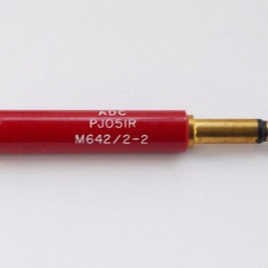 May include: A red audio connector with gold-plated tips and the text "ADC PJ05IR M642/2-2" printed on the side.