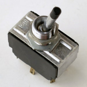 May include: A silver toggle switch with a black knob. The switch has a black plastic base and is labeled "CSI".