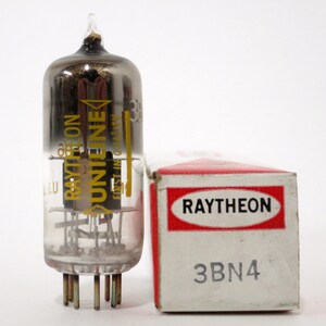 May include: A clear glass vacuum tube with a black metal top and a yellow label that reads "Raytheon" and "Uniline" with the text "First in Quality" in smaller font. The tube is sitting next to a white box with a red label that reads "Raytheon" and "3BN4".