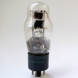 May include: A vintage vacuum tube with a clear glass envelope and a black base. The tube is labeled "SYLVANIA MADE IN U.S.A."
