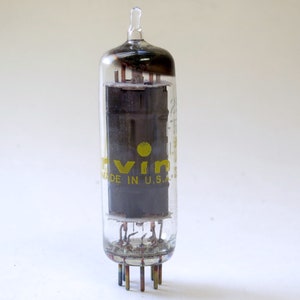 May include: A clear glass vacuum tube with a black metal grid inside. The tube has a yellow label that reads "Eimac" and "Made in U.S.A.".