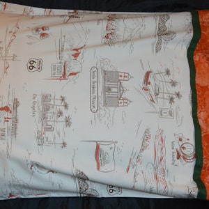 May include: A white pillowcase with a brown and red print of various California landmarks, including Route 66, the Santa Barbara Mission, and the Los Angeles skyline. The pillowcase has a green and orange border.