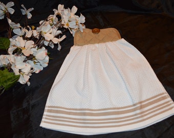 May include: White kitchen towel with brown stripes and a brown quilted potholder with a wooden button.