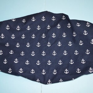 May include: A navy blue fabric seat cover with a white anchor pattern.