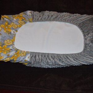 May include: Gray and yellow floral fitted sheet with a gray quilted pattern.
