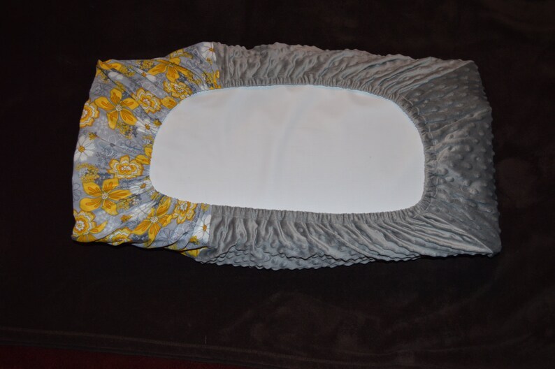 May include: Gray and yellow floral fitted sheet with a gray quilted pattern.