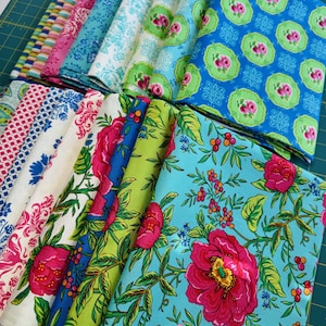 Peut inclure: Une pile de carrés de tissu colorés avec des motifs floraux et géométriques. Les tissus sont dans des tons de rose, bleu, vert et blanc.