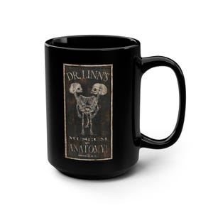 May include: Black coffee mug with a vintage-style illustration of two skeletons. The illustration is on a white rectangle with the text "Dr. Linn's Museum of Anatomy,  New York, N.Y."