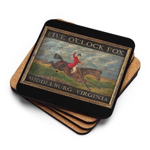 Puede incluir: Un juego de cuatro posavasos de corcho marrón con un posavasos cuadrado negro en la parte superior. El posavasos negro presenta un letrero de estilo vintage con el texto "Five O'Clock Fox Middleburg Virginia" y una pintura de una persona montando a caballo.