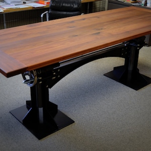 May include: A large wooden table with a dark brown finish and black metal legs. The table has a rectangular top and a unique design with a metal support beam.