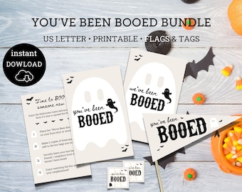 Pode incluir: Um pacote imprimível de Halloween "You've Been Booed" com instruções, etiquetas e uma bandeira. O design apresenta um fantasma com o texto "You've Been Booed" em preto.