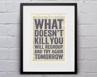 May include: A framed print with a motivational quote on a vintage dictionary page background. The quote reads "What doesn't kill you will regroup and try again tomorrow."