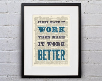 May include: A framed print with a vintage dictionary page background featuring the text "First make it work then make it work better" in blue and purple lettering.