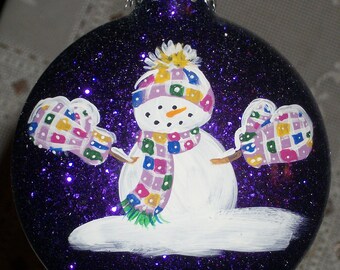 Snowman Ornament - Patch Work Fun - on a 3" Glass disc/Round Ornament w/ Purple Metallic Glitter inside.