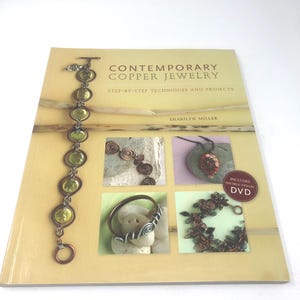 May include: A book titled "Contemporary Copper Jewelry" with step-by-step techniques and projects. The cover features a copper bracelet with green stones and images of copper jewelry. Includes an instructional DVD.