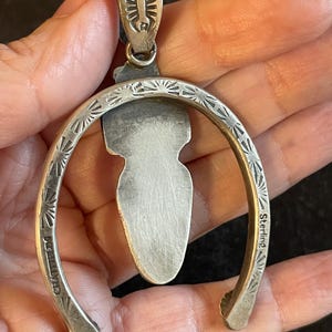 May include: A silver pendant with a horseshoe design. The pendant features a central, elongated stone and is marked "Sterling" and "CHASTFIELD". The horseshoe is decorated with sunburst patterns.