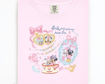 May include: A light pink Comfort Colors sweatshirt featuring a colorful graphic of Minnie Mouse and Daisy Duck. The design includes the phrase "Girls just wanna have fun" and various decorative elements like bows, hearts, and a teacup.