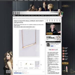May include: A gold necklace with a thin bar pendant that says "LOCAL" on it. The necklace is displayed on a white background.