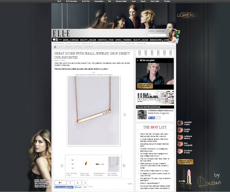May include: A gold necklace with a thin bar pendant that says "LOCAL" on it. The necklace is displayed on a white background.