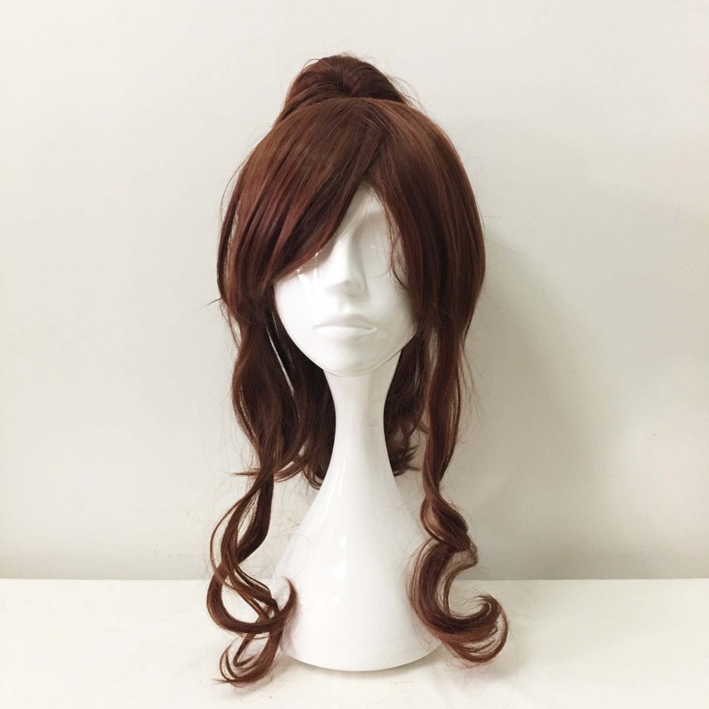 K&ouml;nnte beinhalten: Eine braune Per&uuml;cke mit langen, welligen Haaren, die zu einem Pferdeschwanz gebunden sind. Die Per&uuml;cke befindet sich auf einem wei&szlig;en Mannequin-Kopf.