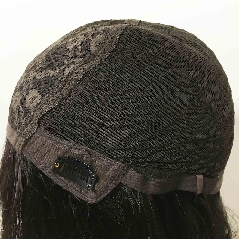 May include: A black wig with a lace front and adjustable straps. The wig has a black mesh cap with a brown lace border. The wig has a comb on the back.