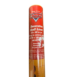 May include: A cylindrical roll of Disney Pixar Cars decorative shelf liner with a bright red background. The label features the Cars logo, the text Decorative Shelf Liner, and dimensions of 18 x 40 inches. The packaging indicates it is removable.