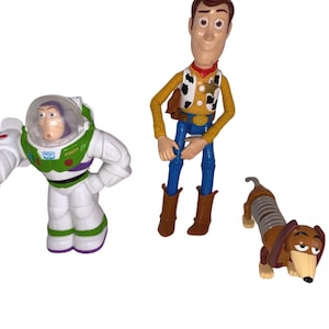 Tres figuras de personajes de Toy Story: Buzz, Woody y Slinky imagen 1