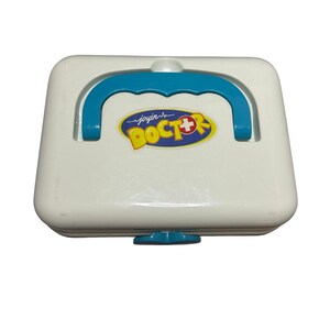 May include: A white toy doctor's kit with a blue handle and accents. The kit features a yellow and blue logo that reads "joyin DOCTOR" with a red cross symbol. The kit has a small blue latch on the bottom.