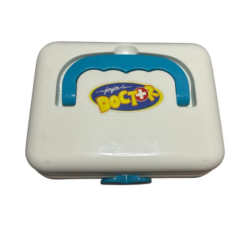 May include: A white toy doctor's kit with a blue handle and accents. The kit features a yellow and blue logo that reads "joyin DOCTOR" with a red cross symbol. The kit has a small blue latch on the bottom.
