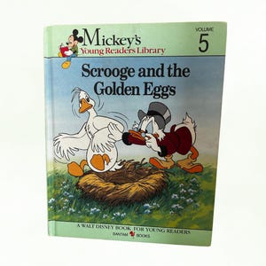 May include: A vintage copy of "Scrooge and the Golden Eggs" from the Mickey's Young Readers Library. The cover features a cartoon illustration of Scrooge McDuck and a goose. The book is volume 5 and is a Walt Disney book.