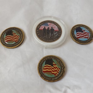 May include: A set of commemorative coins with patriotic designs. The coins display the American flag and the words "United Together in the Fight Against Terrorism." One coin is cased and reads "We Will Never Forget, Some Gave All."