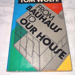 May include: A vintage paperback book titled "From Bauhaus to Our House" by Tom Wolfe. The cover features a geometric design in grey, black, blue, green, orange, and yellow. The book's title is prominently displayed in bold, black lettering.