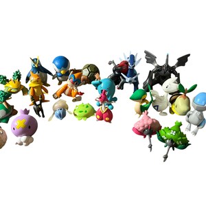 May include: A collection of twenty-two small, colorful plastic creature figurines in various shapes and poses. The set includes diverse characters with distinct features such as wings, shells, and spikes, rendered in shades of blue, green, orange, pink, and black.