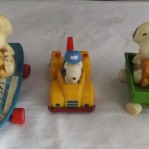 Drei Snoopy Die Cast und Kunststofffiguren auf Rollen