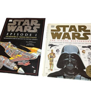 Könnte beinhalten: Zwei Star Wars Bücher. Eines trägt den Titel "Episode I Incredible Cross-Sections" mit einer detaillierten Illustration eines Raumschiffs. Das andere ist "The Visual Dictionary" mit Darth Vader. Beide Bücher haben goldenen und schwarzen Text.