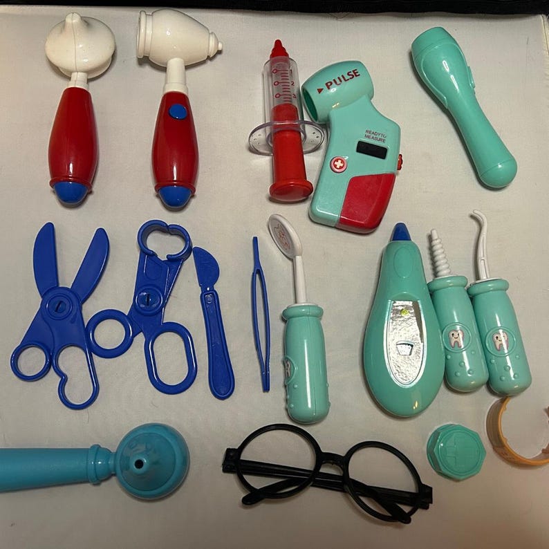 May include: A collection of toy medical tools, including a stethoscope, otoscope, syringe, and thermometer. The set features blue, red, white, and green plastic pieces, including scissors, tweezers, and dental tools. A pair of black glasses is also included.