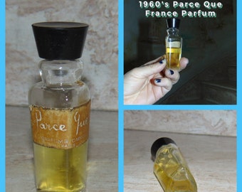 May include: A vintage glass bottle of Parce Que perfume from France. The bottle has a black plastic cap and a brown label with the words "Parce Que" and "Parfums Carolyne Paris".