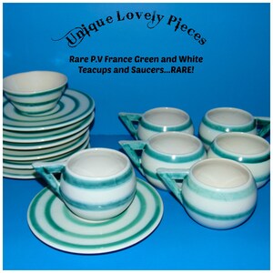 May include: Set of six green and white striped teacups and saucers. The teacups have a rounded shape and a unique angled handle. The saucers have a matching striped design.