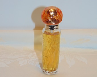 May include: A clear glass bottle of perfume with a textured design. The bottle has a gold cap with a clear, orange, textured top.