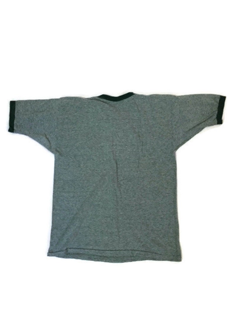 May include: A grey ringer t-shirt with a dark green trim around the collar and sleeve ends. The short-sleeved shirt is made of a soft material. The shirt is laid flat on a white surface.