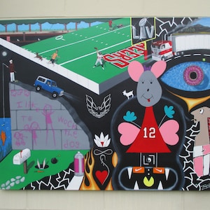 May include: A colorful mural with a variety of images, including a football field, a mouse wearing a red jersey with the number 12, a car, a donut, and a goat. The mural is painted on a white wall and has a black background.