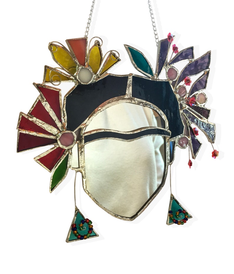 Peut inclure: Un miroir en verre color&eacute; avec un cadre en forme de c&oelig;ur et un motif floral color&eacute;. Le miroir est entour&eacute; de fleurs dans des tons de rouge, jaune, vert, violet et rose.