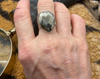 May include: A silver ring featuring a large, faceted, teardrop-shaped pyrite stone.