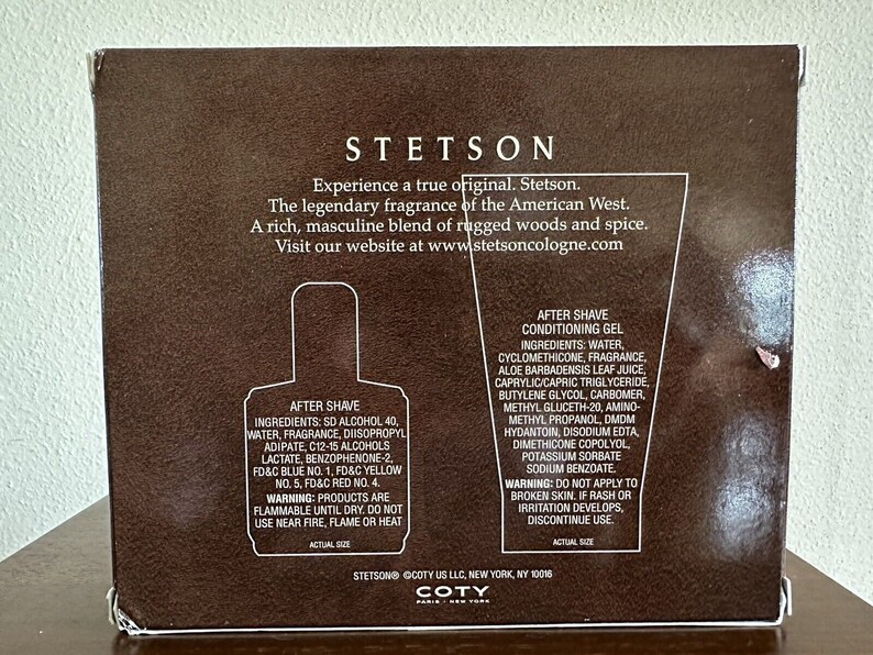 May include: A brown box with a white label featuring the Stetson logo and product information. The label includes the text "Experience a true original. Stetson." and "The legendary fragrance of the American West." The box contains two bottles of aftershave, one with a blue label and the other with a white label. The bottles are labeled "After Shave" and "After Shave Conditioning Gel".