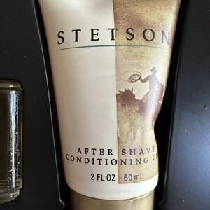 May include: A white tube of Stetson After Shave Conditioning Gel with a gold cap. The tube has a brown and white image of a cowboy on a horse. The text on the tube reads "Stetson After Shave Conditioning Gel 2 fl oz 60 ml."