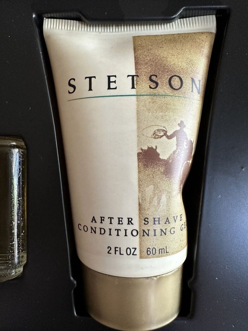 May include: A white tube of Stetson After Shave Conditioning Gel with a gold cap. The tube has a brown and white image of a cowboy on a horse. The text on the tube reads "Stetson After Shave Conditioning Gel 2 fl oz 60 ml."