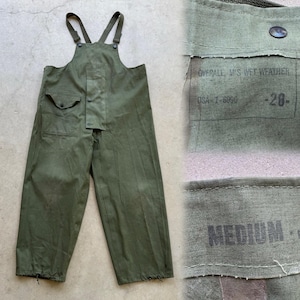 May include: Olive green waterproof overalls with suspenders, two front pockets, and button closures. The tag reads "OVERALL M'S WET WEATHER" and "USA I-6990". The size is marked as "MEDIUM".